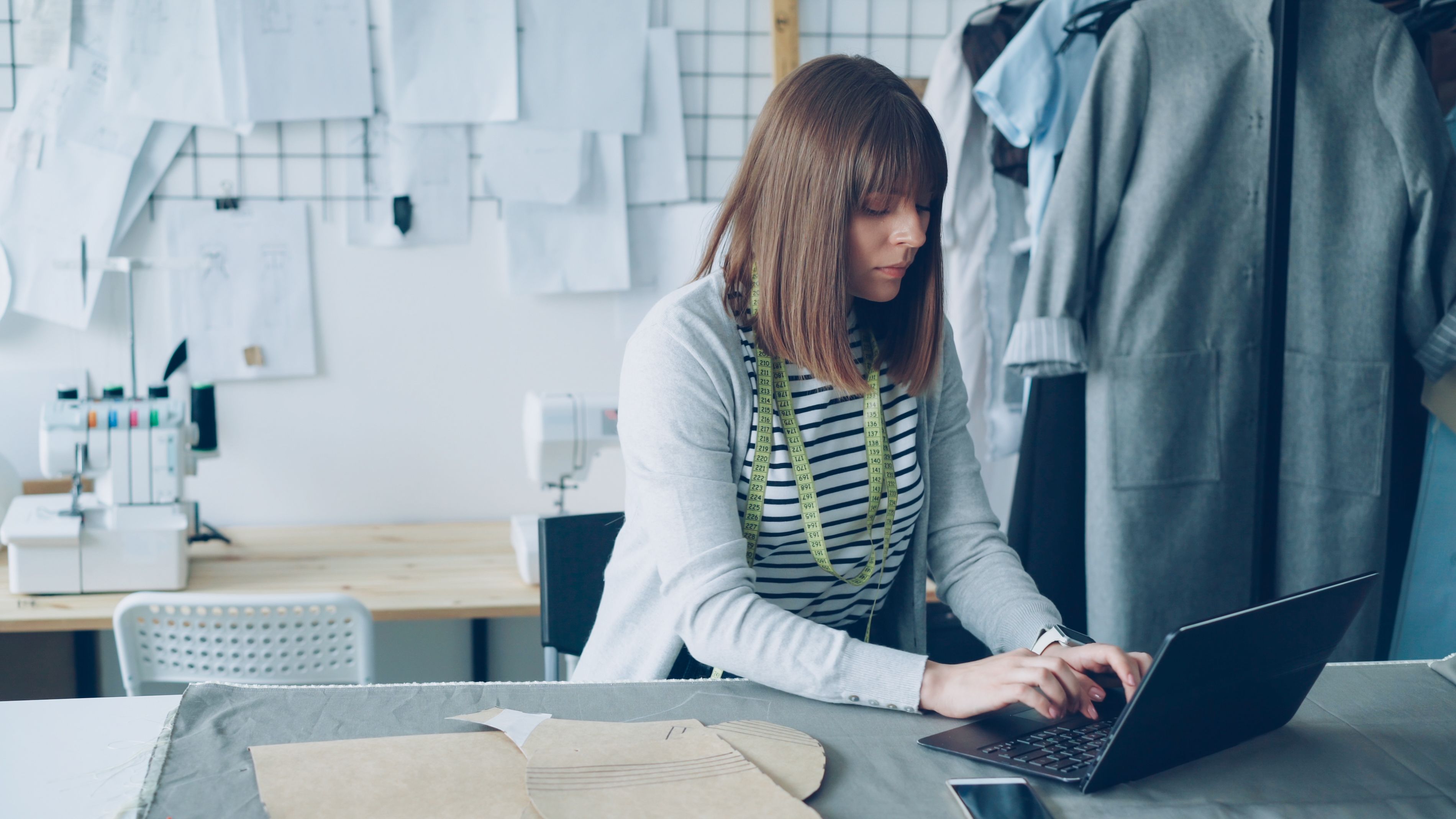 Fashion designer coordinating product work on a laptop